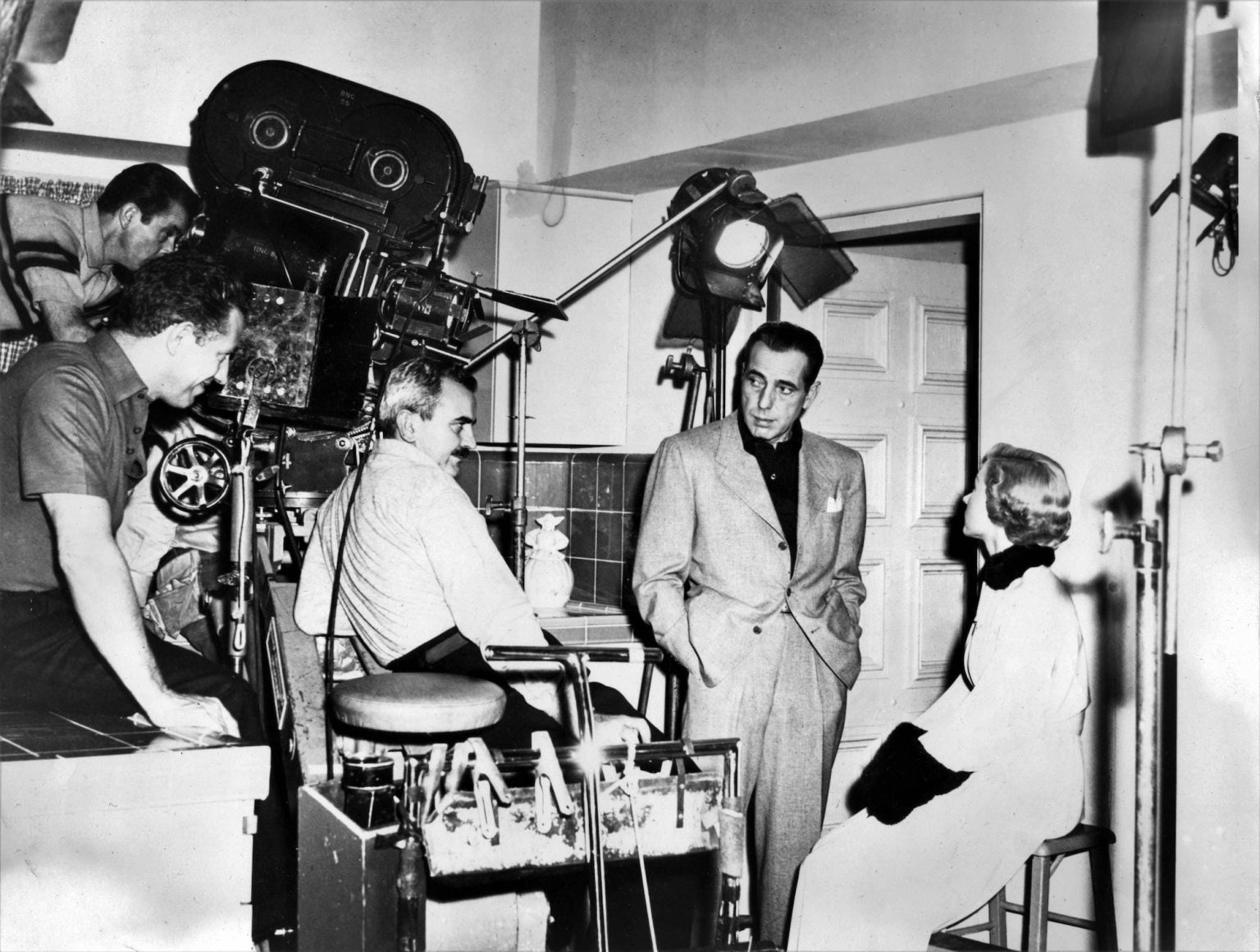 NICHOLAS RAY Cinematographer BURNETT GUFFEY HUMPHREY BOGART and GLORIA GRAHAME on set candid during filming of IN A LONELY PLACE 1950 director NICHOLAS RAY story Dorothy B. Hughes Santana Pictures Corporation / Columbia Pictures