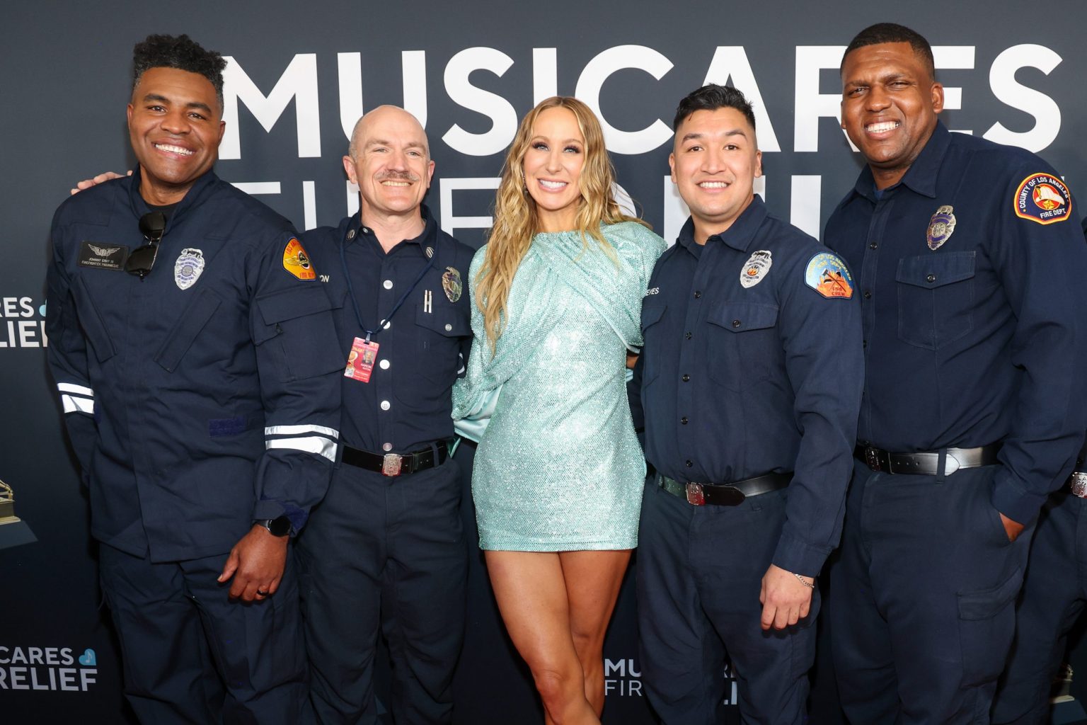 LOS ANGELES, CALIFORNIA - FEBRUARY 02: Nikki Glaser poses with Firefighters during the 67th Annual GRAMMY Awards at Crypto.com Arena on February 02, 2025 in Los Angeles, California. (Photo by Kevin Mazur/Getty Images for The Recording Academy)