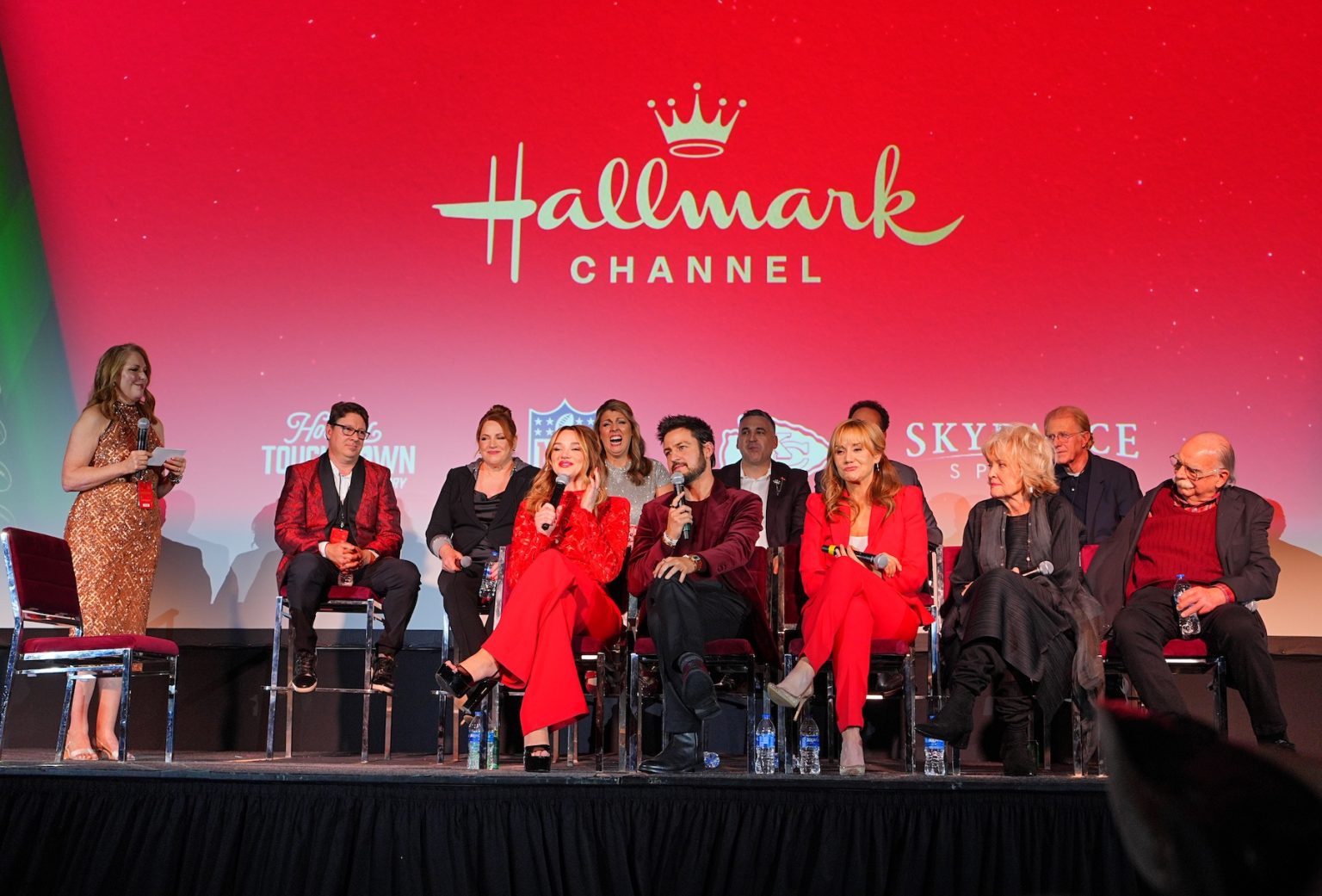 KANSAS CITY, MISSOURI - NOVEMBER 30: (L-R) Annie Howell, Dustin Rikert, Julie Sherman Wolfe, Hunter King, Samantha DiPippo, Tyler Hynes, David Wulf, Megyn Price Christine Ebersole, Ed Begley Jr. and Richard Riehle speak onstage during Hallmark's Premiere Screening of Holiday Touchdown: A Chiefs Love Story on November 30, 2024 in Kansas City, Missouri. (Photo by Kyle Rivas/Getty Images for Hallmark Media)