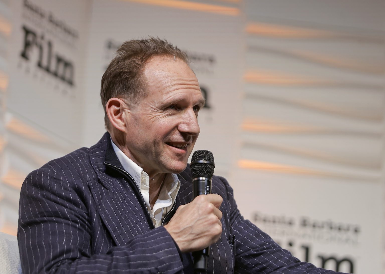 SANTA BARBARA, CALIFORNIA - FEBRUARY 06: Honoree Ralph Fiennes speaks onstage at the Outstanding Performer of the Year Award ceremony during the 40th Santa Barbara International Film Festival at Arlington Theatre on February 06, 2025 in Santa Barbara, California. (Photo by Tibrina Hobson/Getty Images for Santa Barbara International Film Festival)
