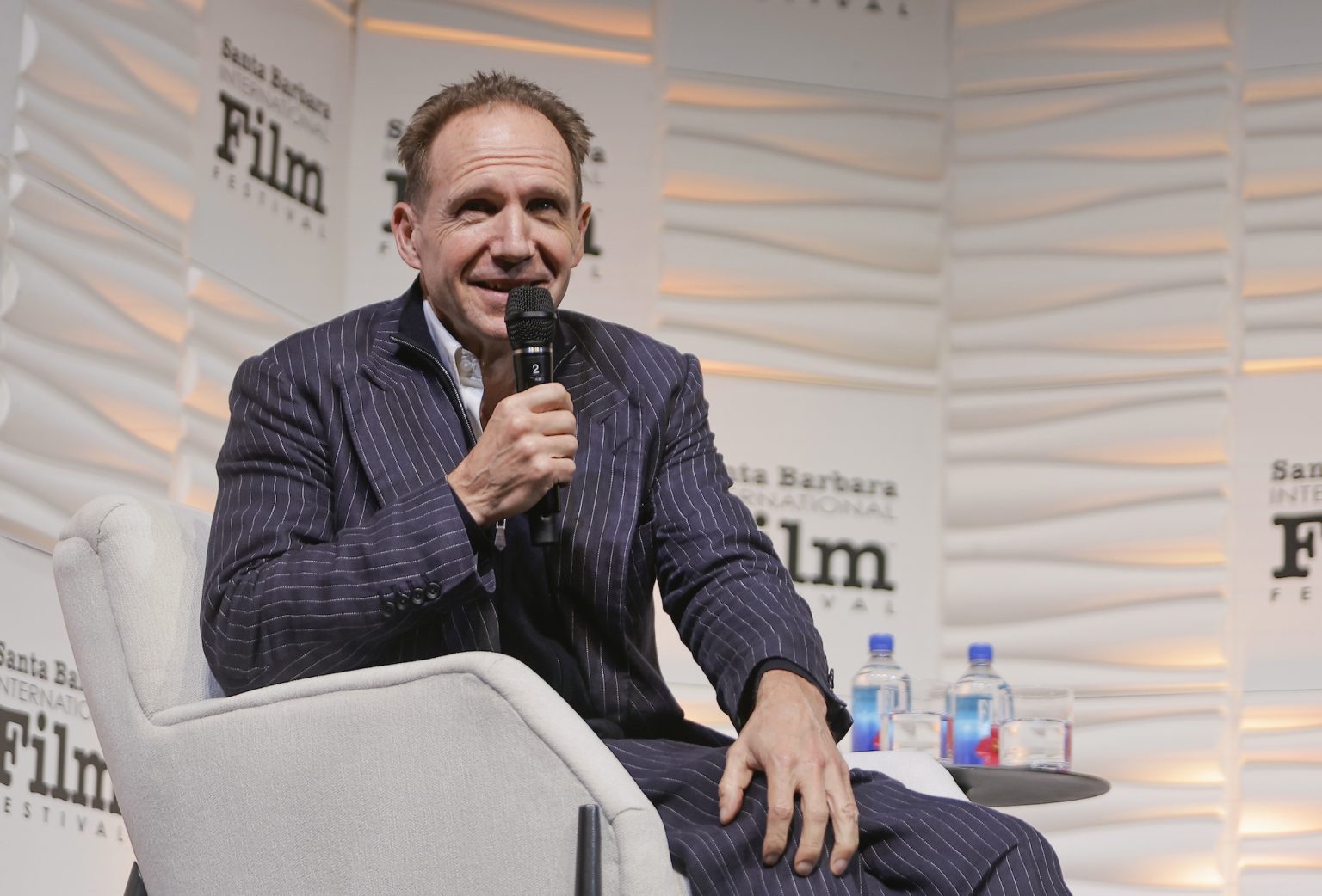 SANTA BARBARA, CALIFORNIA - FEBRUARY 06: Honoree Ralph Fiennes speaks onstage at the Outstanding Performer of the Year Award ceremony during the 40th Santa Barbara International Film Festival at Arlington Theatre on February 06, 2025 in Santa Barbara, California. (Photo by Tibrina Hobson/Getty Images for Santa Barbara International Film Festival)