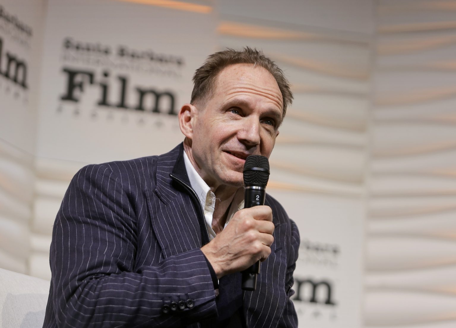 SANTA BARBARA, CALIFORNIA - FEBRUARY 06: Honoree Ralph Fiennes speaks onstage at the Outstanding Performer of the Year Award ceremony during the 40th Santa Barbara International Film Festival at Arlington Theatre on February 06, 2025 in Santa Barbara, California. (Photo by Tibrina Hobson/Getty Images for Santa Barbara International Film Festival)