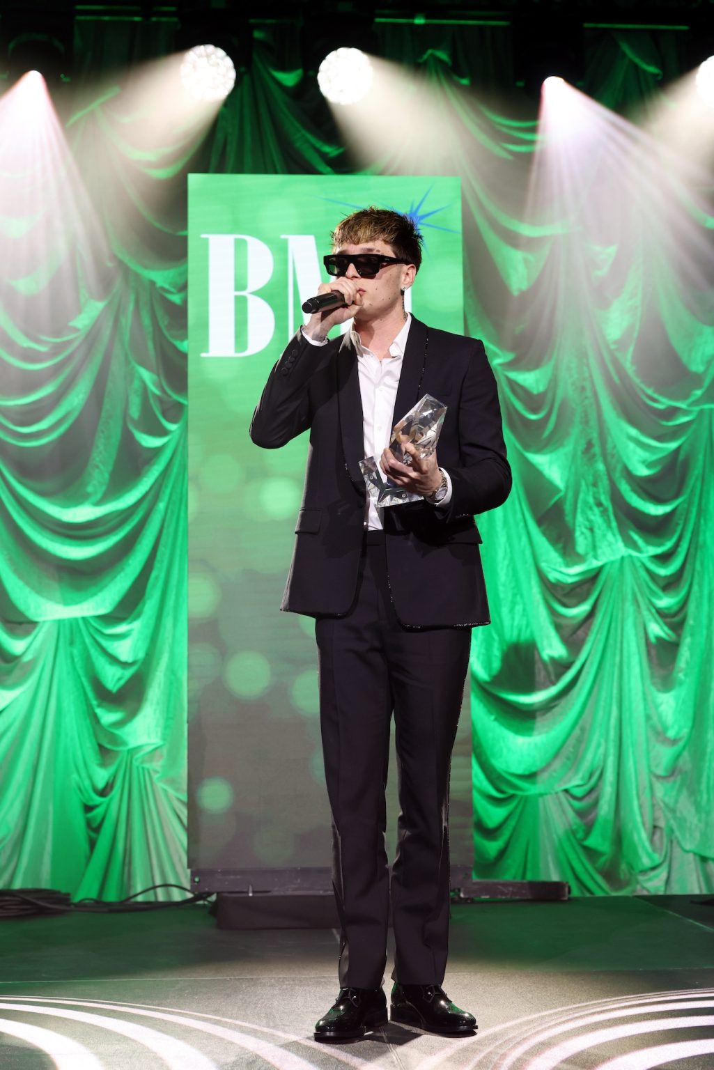 MIAMI, FLORIDA - MARCH 06: Peso Pluma speaks onstage for the BMI Latin Awards on March 06, 2025 in Miami, Florida. (Photo by Alexander Tamargo/Getty Images for BMI)