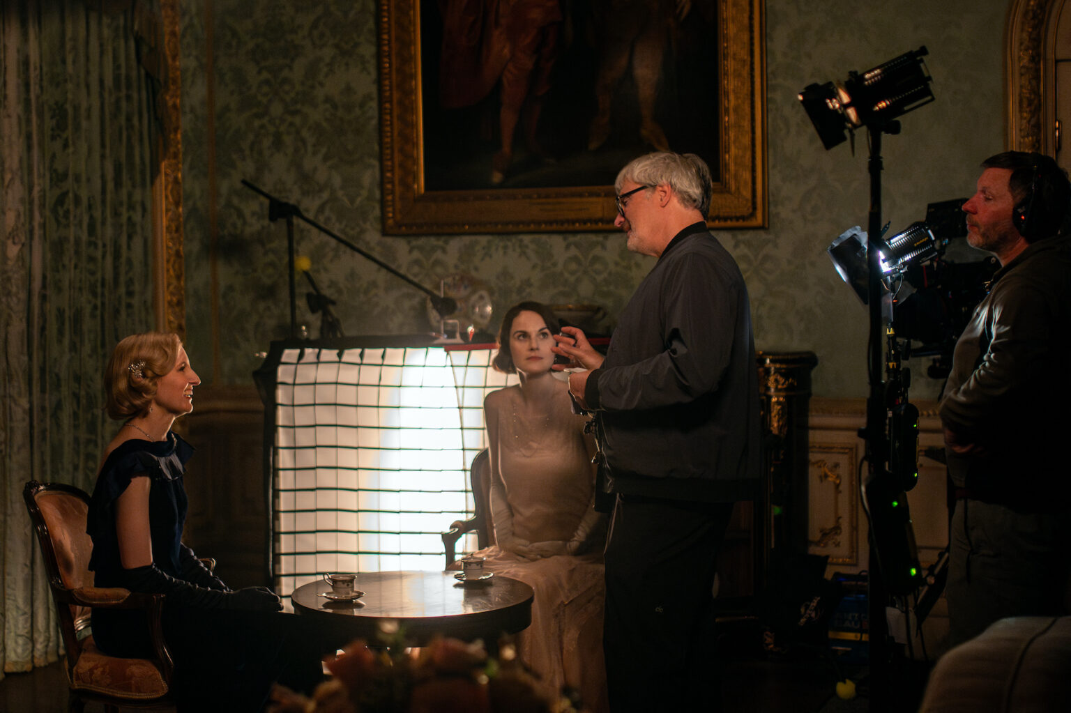 Actors Laura Carmichael and Michelle Dockery with director Simon Curtis on the set of their film DOWNTON ABBEY: The Grand Finale, a Focus Features release. Credit: Rory Mulvey / © 2025 FOCUS FEATURES LLC