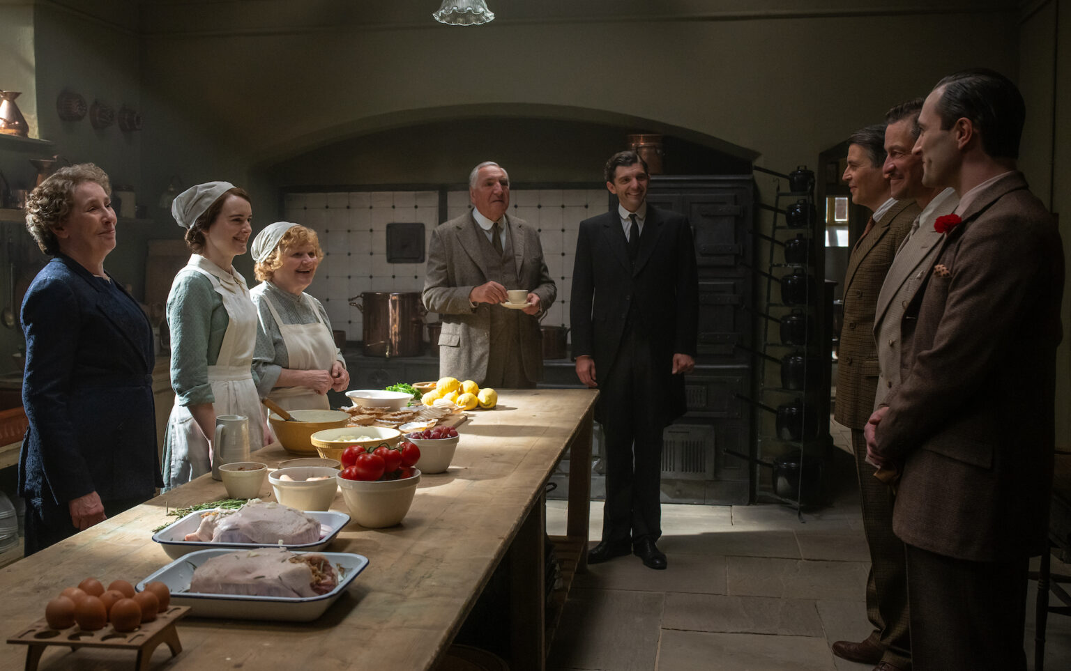 (L to R) Phyllis Logan stars as Mrs. Hughes, Sophie McShera as Daisy Parker, Lesley Nicol as Mrs. Patmore, Jim Carter as Mr. Carson, Michael Fox as Andy Parker, Robert James-Collier as Thomas Barrow, Dominic West as Guy Dexter and Arty Froushan as Noël Coward in DOWNTON ABBEY: The Grand Finale, a Focus Features release. Credit: Rory Mulvey / © 2025 FOCUS FEATURES LLC