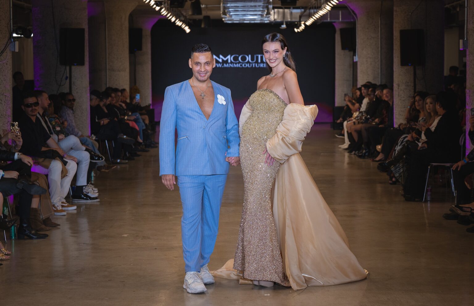LOS ANGELES, CALIFORNIA - OCTOBER 16: Designer Cristian Munoz and model Rachel Pizzolato walk the runway at the MNM Couture show during Los Angeles Fashion Week Powered By Art Hearts Fashion at The New Mart on October 16, 2025 in Los Angeles, California. (Photo by Mark Gunter/Getty Images for Art Hearts Fashion)