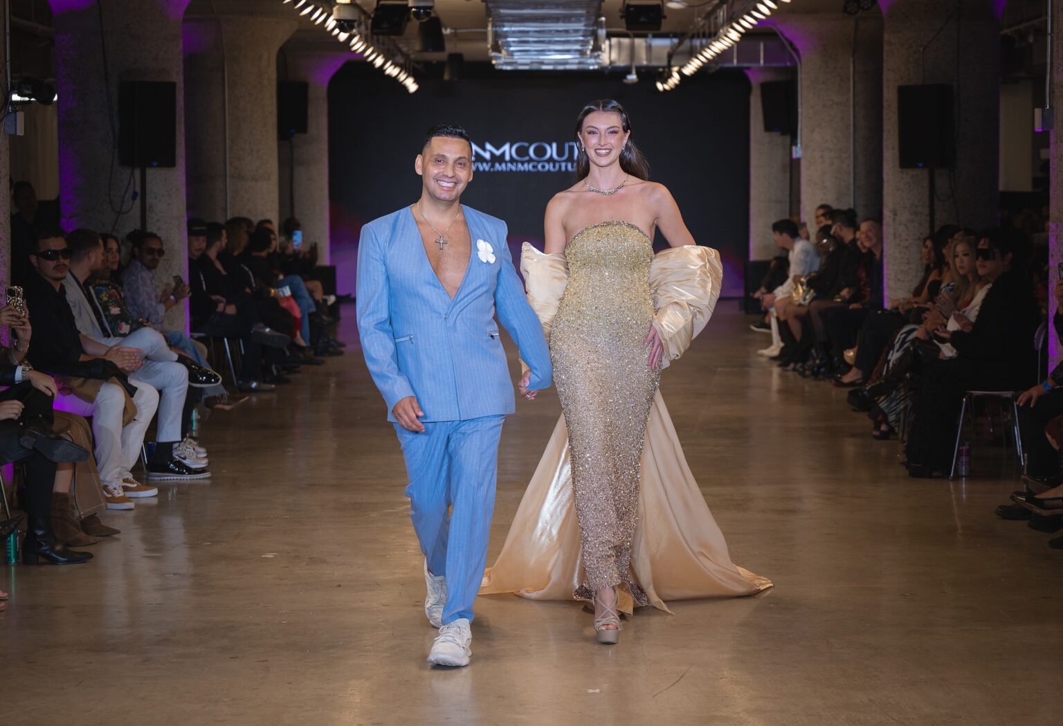 LOS ANGELES, CALIFORNIA - OCTOBER 16: Designer Cristian Munoz and model Rachel Pizzolato walk the runway at the MNM Couture show during Los Angeles Fashion Week Powered By Art Hearts Fashion at The New Mart on October 16, 2025 in Los Angeles, California. (Photo by Mark Gunter/Getty Images for Art Hearts Fashion)