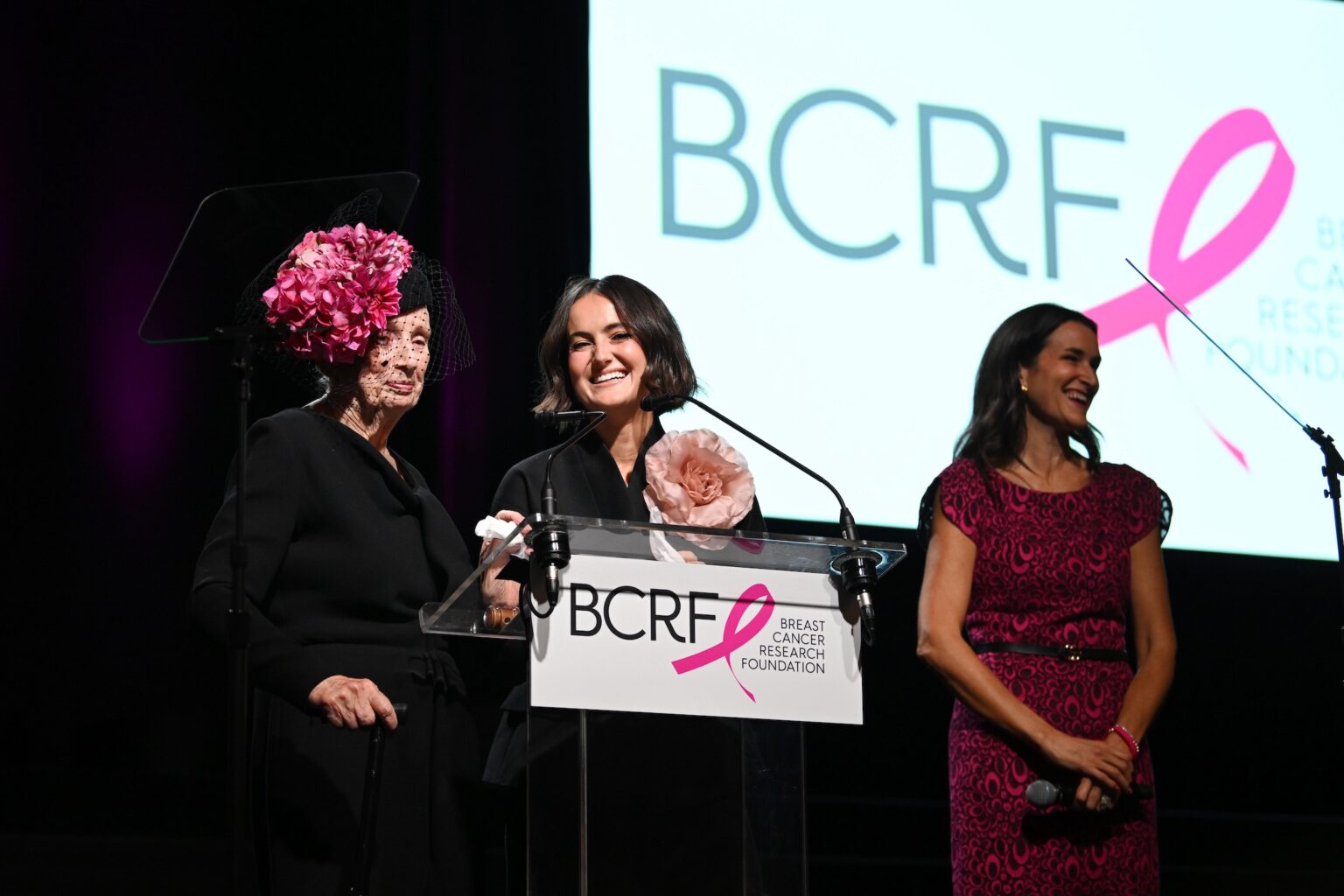 NEW YORK, NEW YORK - OCTOBER 30: (L-R) Roslyn Goldstein, Eliana Lauder and Lydia Fenet speak onstage at the Breast Cancer Research Foundation New York Symposium & Awards Luncheon at New York Hilton Midtown on October 30, 2025 in New York City. (Photo by Bryan Bedder/Getty Images for Breast Cancer Research Foundation)