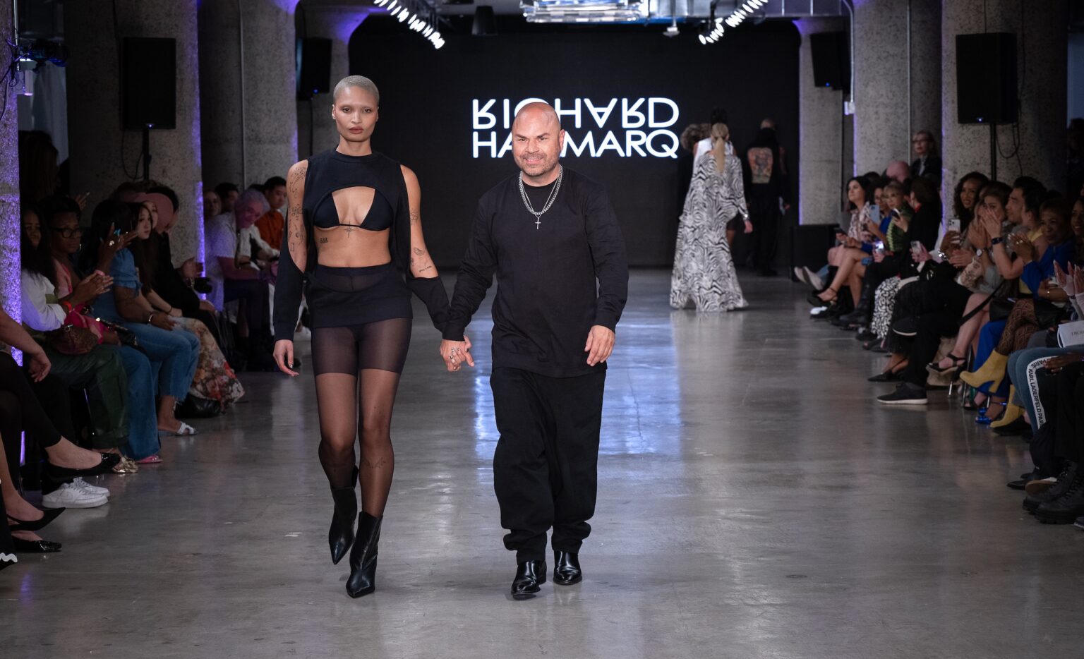 LOS ANGELES, CALIFORNIA - OCTOBER 18: Designer Richard Hallmarq and model walk the runway at the Richard Hallmarq show during Los Angeles Fashion Week Powered By Art Hearts Fashion at The New Mart on October 18, 2025 in Los Angeles, California. (Photo by Mark Gunter/Getty Images for Art Hearts Fashion)