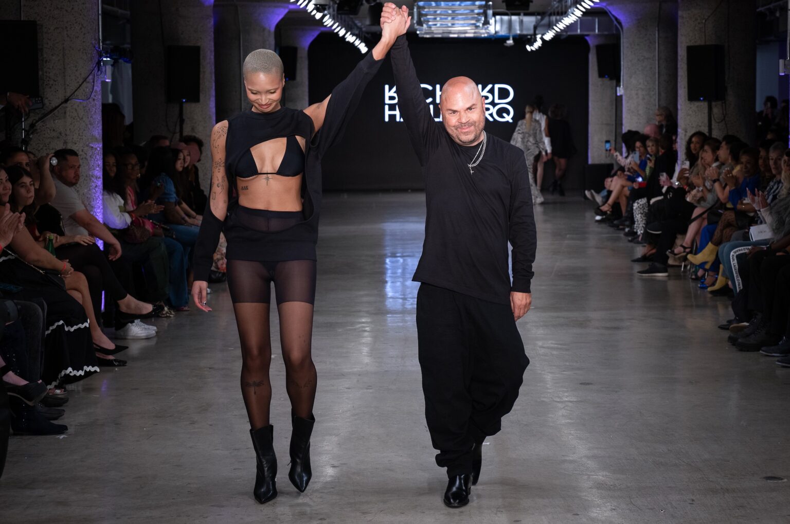 LOS ANGELES, CALIFORNIA - OCTOBER 18: Designer Richard Hallmarq and model walk the runway at the Richard Hallmarq show during Los Angeles Fashion Week Powered By Art Hearts Fashion at The New Mart on October 18, 2025 in Los Angeles, California. (Photo by Mark Gunter/Getty Images for Art Hearts Fashion)