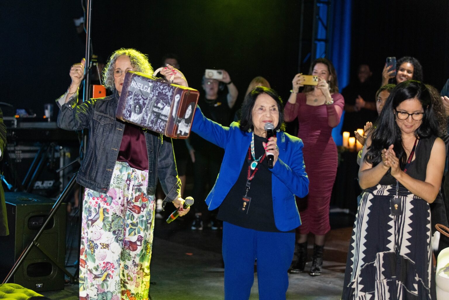 LOS ANGELES, CALIFORNIA - MARCH 1: Gina Belafonte stands with Dolores Huerta, holding the lifetime achievement award created by Douglas Miles, a commemorative suitcase honoring her farmworker, movement, and history during the inaugural Sankofa.org Social Justice Awards at Chaplin Studios on March 1, 2026 in Los Angeles, California. (Photo by Todd Westphal / Sankofa.org)