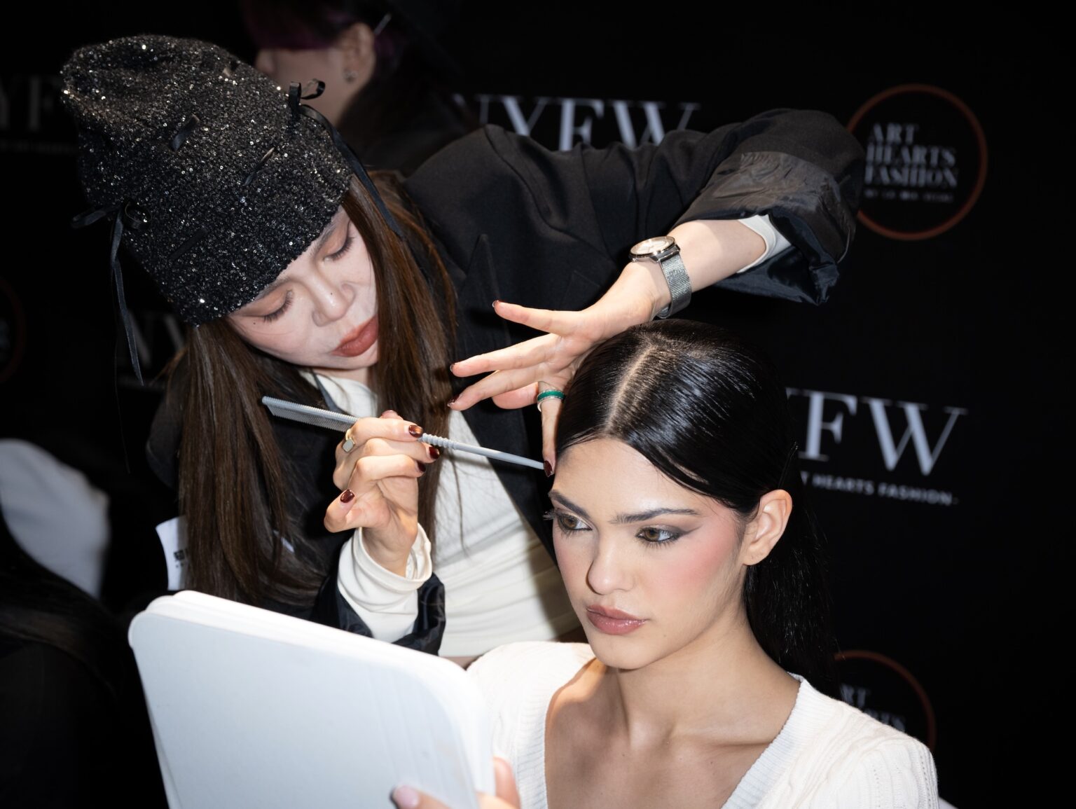 WUXI, CHINA - MARCH 19: A makeup artist applies makeup to a model backstage during Art Hearts Fashion Wuxi China at Smile Square Nianhua Bay on March 19, 2026 in Wuxi Jiangsu Province, China. (Photo by Mark Gunter/Getty Images for Art Hearts Fashion)