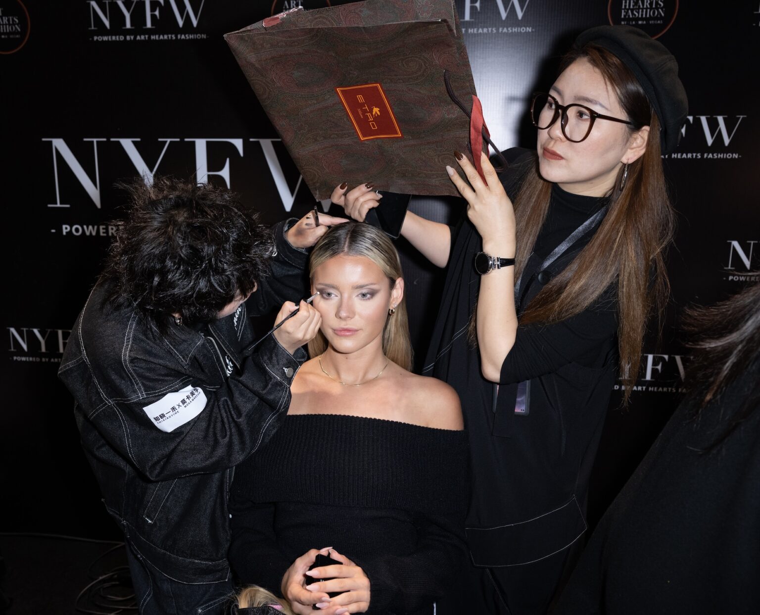 WUXI, CHINA - MARCH 19: A makeup artist applies makeup to a model backstage during Art Hearts Fashion Wuxi China at Smile Square Nianhua Bay on March 19, 2026 in Wuxi Jiangsu Province, China. (Photo by Mark Gunter/Getty Images for Art Hearts Fashion)