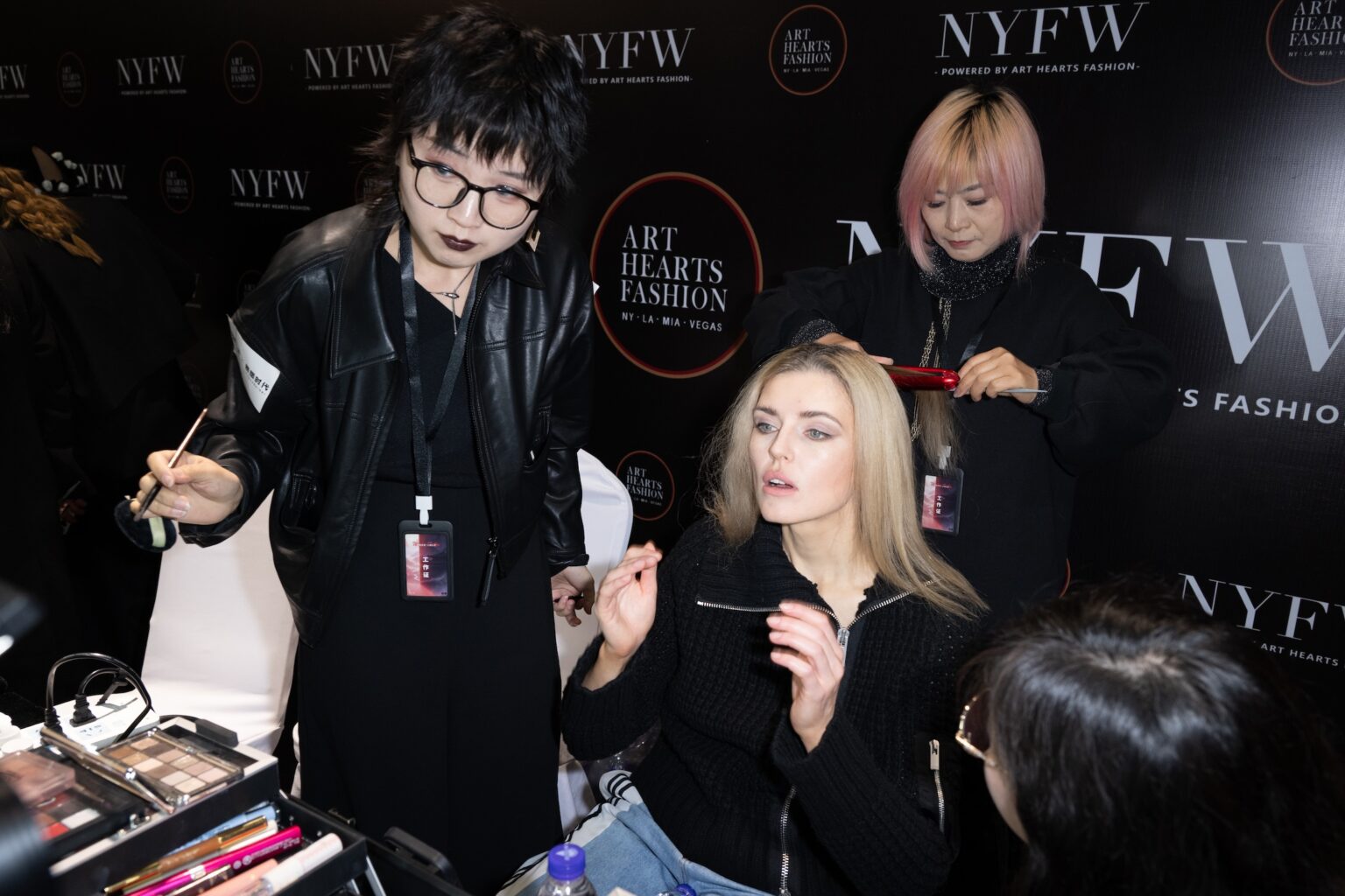 WUXI, CHINA - MARCH 19: A makeup artist applies makeup to a model backstage during Art Hearts Fashion Wuxi China at Smile Square Nianhua Bay on March 19, 2026 in Wuxi Jiangsu Province, China. (Photo by Mark Gunter/Getty Images for Art Hearts Fashion)
