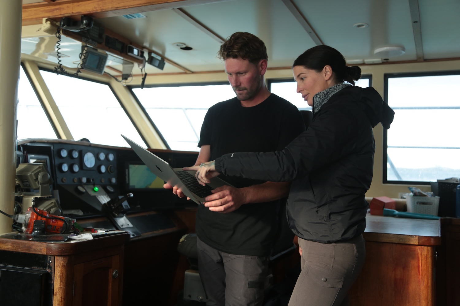 Dr. Riley Elliot and Kori Burkhardt reviewing data from shark tags in boat cabin