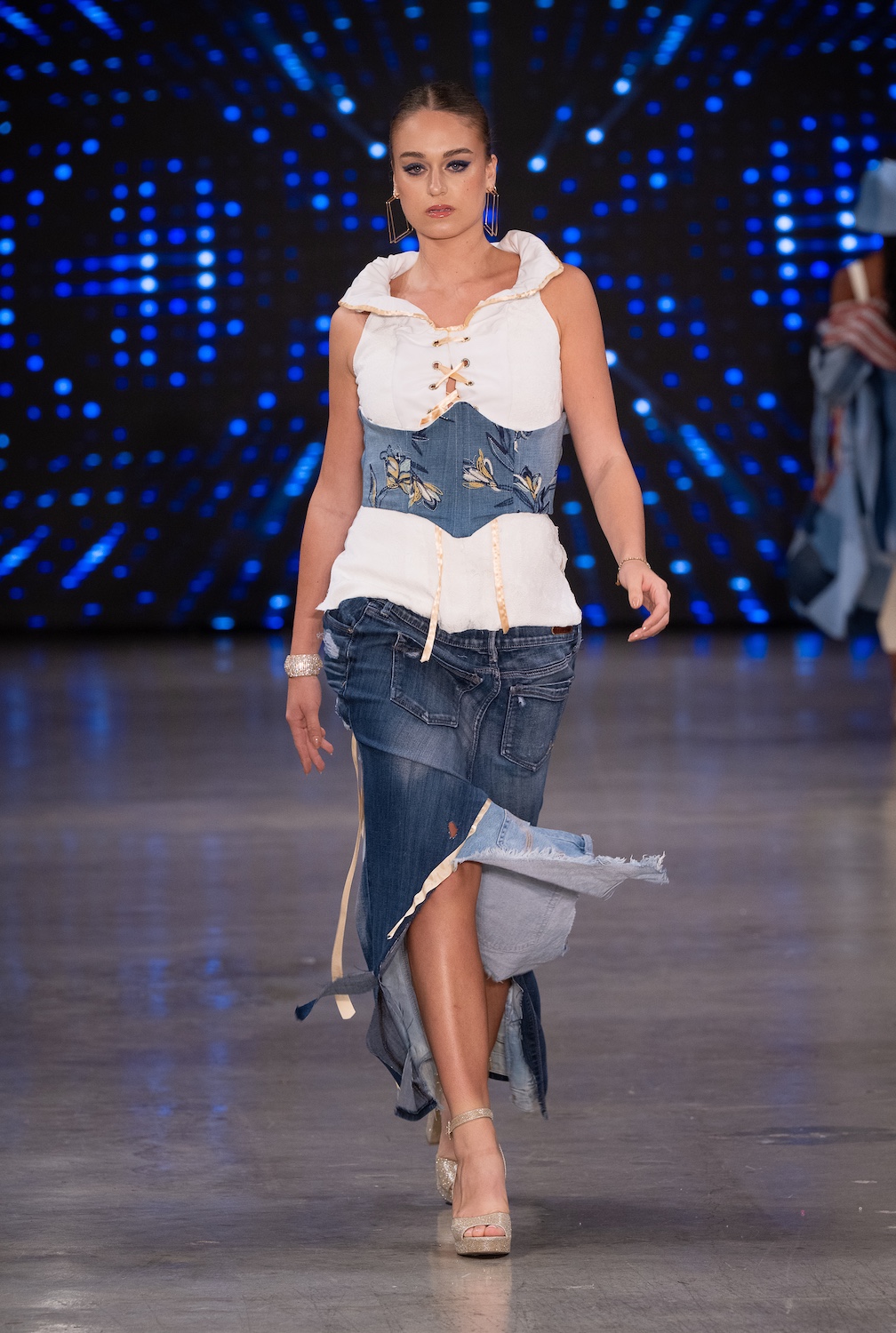 LOS ANGELES, CALIFORNIA - OCTOBER 18: A model walks the runway at the Upcycle Denim & Sustainability Project 2025 show during Los Angeles Fashion Week Powered By Art Hearts Fashion at The New Mart on October 18, 2025 in Los Angeles, California. (Photo by Mark Gunter/Getty Images for Art Hearts Fashion)